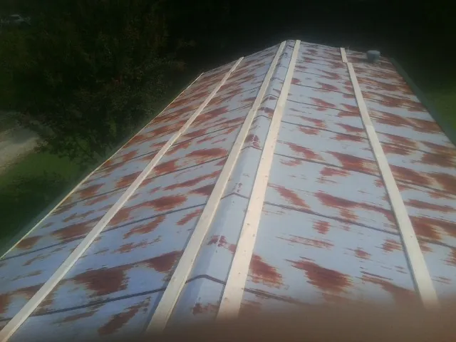 Rusted metal roof panels with new wood purlins before replacement — Storm Damage Roof Repair in Lavonia by Roofing Brothers